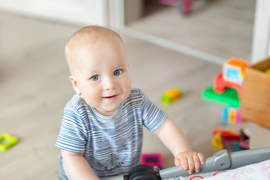 Çocuk oyuncakları ile oynarken şirin bebek çocuk portresi. Çok güzel çocuk evde gülümseyen