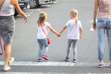 Grup birlikte yaya geçidi yürüyen dört kız arkadaşıyla. İki genç kadın ile iki kızı shopping mall yakınındaki açık havada eğleniyor. Çocuklar ve yetişkinler dostluk kavramı.
