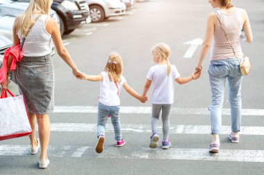 Grup birlikte yaya geçidi yürüyen dört kız arkadaşıyla. İki genç kadın ile iki kızı shopping mall yakınındaki açık havada eğleniyor. Çocuklar ve yetişkinler dostluk kavramı.