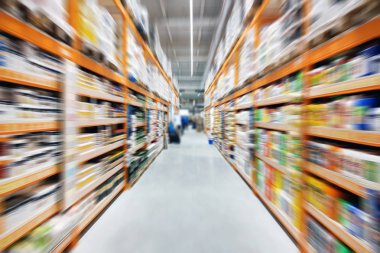 Donanım inşaat süpermarket koridor ve raflar. Perspektif görünümü hipermarket satır ürünleri ile. Soyut alışveriş ve ticaret arka plan bulanık.