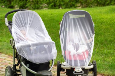 Bebek arabalarının içinde iki bebek çocuk koruyucu yürüyüş sırasında net ile kaplı. Anti-sivrisinek beyaz kapaklı bebek arabası. Açık yürüyüş sezon sırasında çocuklar için Midge koruma.