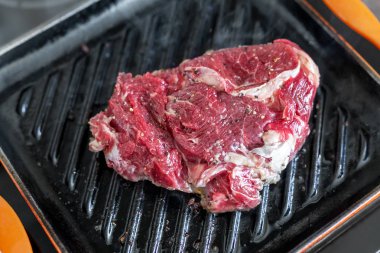 Yakın çekim ham lezzetli taze kaburga eti ızgara dökme demir tava üzerinde. Zemin biber coocked Barbekü Tarih ile terbiyeli organik sığır eti