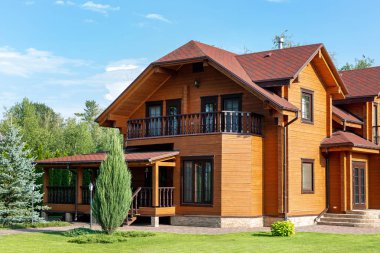 Güzel lüks büyük ahşap ev. Yeşil çim ile ahşap yazlık villa, Bahçe ve mavi gökyüzü arka plan üzerinde.
