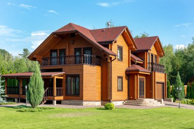 Güzel lüks büyük ahşap ev. Yeşil çim ile ahşap yazlık villa, Bahçe ve mavi gökyüzü arka plan üzerinde.