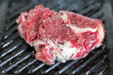 Yakın çekim ham lezzetli taze kaburga eti ızgara dökme demir tava üzerinde. Zemin biber coocked Barbekü Tarih ile terbiyeli organik sığır eti