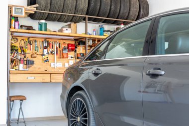 Lüks araba park edilmiş geniş ferah özel ev garaj. Büyük ahşap tezgah birçok araç, arka plan ile. Yedek sezon tekerlekler depolama. DIY, self servis ve onarım