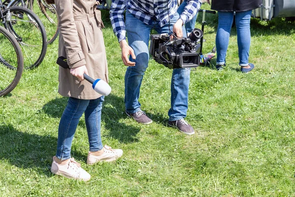 Repórteres de TV trabalhando ao ar livre. Journalsit e cinegrafista fazendo relatório na rua no dia ensolarado brilhante — Fotografia de Stock