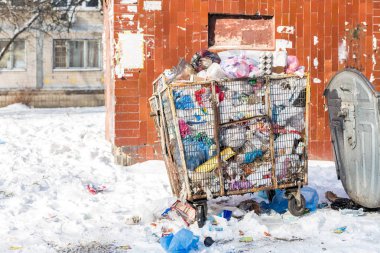 Şehir sokak üzerinde atık konteyner dolu. Çöp kutusu için Plastik döküm metal kafes yapılmış. Çevre kirliliği. Geri dönüşüm plastik ürünler.