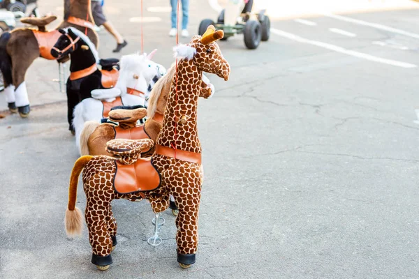Group of large wheeled animal toys for riding. Children fun transport hire service. Recreation area in city park . Family outdoor activity. — Stock Image Group Large Wheeled Animal Toys Riding Children Fun Transport Hire Stock Photo