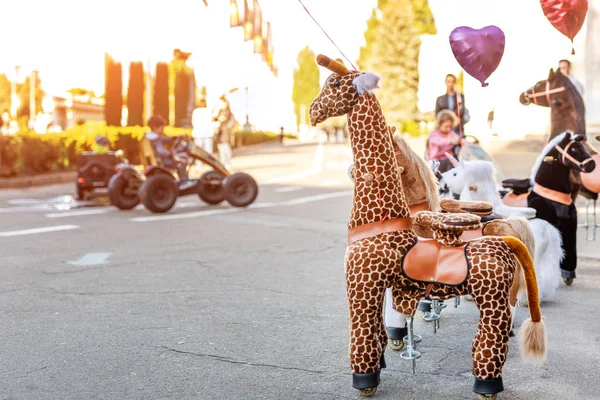 Group of large wheeled animal toys for riding. Children fun transport hire service. Recreation area in city park . Family outdoor activity. — Stock Image Group Large Wheeled Animal Toys Riding Children Fun Transport Hire Stock Photo