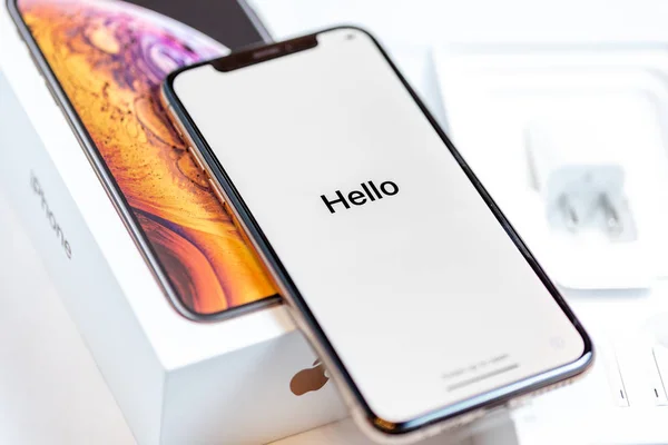 12th October,2018-Kiev,Ukraine: Latest Iphone XS on opened box on white table. Newest Apple smartphone on white branded box in mobile store. Edge frameless screen with loading Hello text — Stock Photo, Image