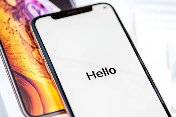 12th October,2018-Kiev,Ukraine: Latest Iphone XS on opened box on white table. Newest Apple smartphone on white branded box in mobile store. Edge frameless screen with loading Hello text — Stock Photo, Image