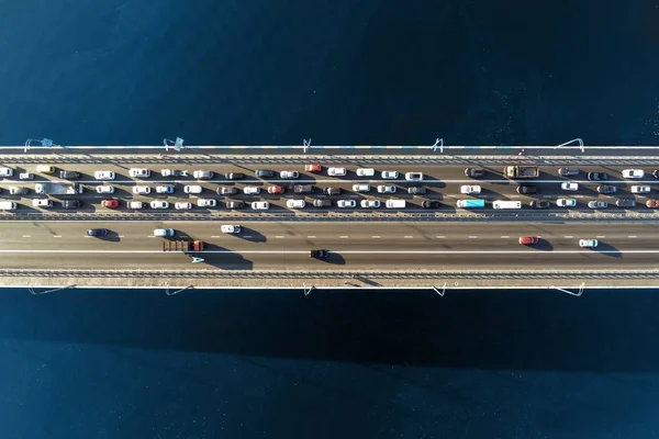 Luftaufnahme einer Straßenbrücke über den Fluss mit starkem Stau in eine Richtung. Berufsverkehr mit Stau und Überlastung der Straßeninfrastruktur. Auflösung des Staus — Stockfoto