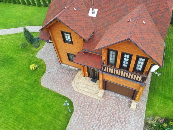 Hermosa casa de madera grande de lujo. Chalet de madera con césped verde, jardín y cielo azul en el fondo — Foto de Stock