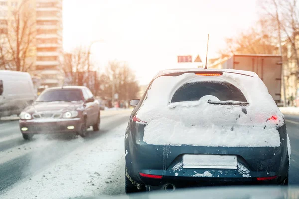 冬の滑りやすい雪道で街を移動する車 寒い冬の雪と吹雪の後の雪のドリフトで覆われた車 天気予報 — ストック写真