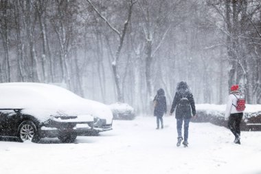İnsanlar şehirde sokak yürüyüş sırasında yoğun kar yağışı karla kaplı. Town kış adlı kar fırtınasında. Doğal felaketler, kar fırtınası