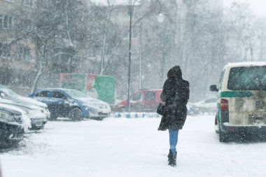 İnsanlar şehirde sokak yürüyüş sırasında yoğun kar yağışı karla kaplı. Town kış adlı kar fırtınasında. Doğal felaketler, kar fırtınası