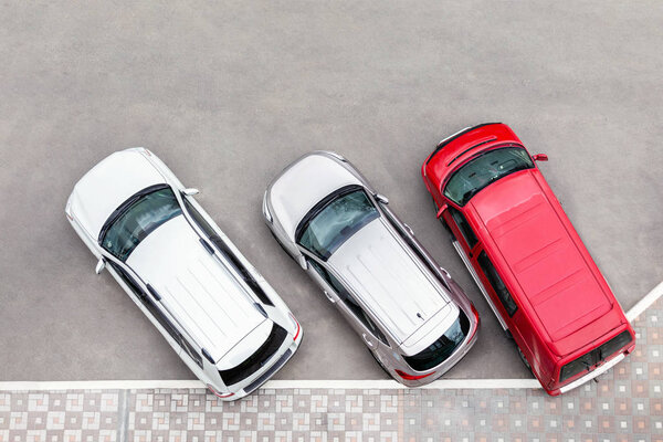 Car parked in aprking area at city street. Vehicles stand in row near road. View from above