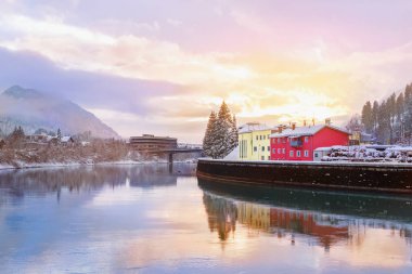 River Inn Kufstein kasabasında ağaçlar ile üzerinde güzel doğal günbatımı kar ve arka planda dağlar kaplı. Avusturya dağ manzara. Seyahat ve hedef.