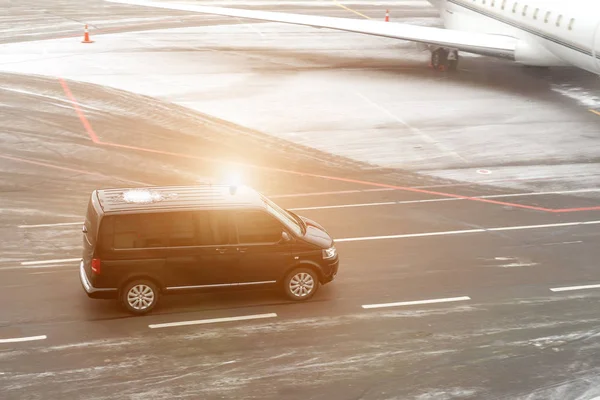 Siyah VIP Servisi van Havaalanı Taksi üzerinde arka plan bulanık bir özel jet ile çalışan. İş sınıfı Servisi Havaalanı'nda. Güvenlik İstihbarat Teşkilatı Havaalanı'nda aceleyle. tonda