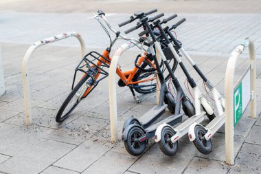 Bisiklet ve elektrikli scooter şehir cadde üzerinde park etmiş. Sokak taşıma self-servis Kiralama Servisi. Smartphone uygulama ile kentsel araç kiralamak. Sıfır emisyon yeşil eko enerji