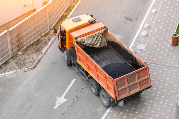 Camión volquete industrial pesado descarga asfalto caliente. Construcción y renovación de carreteras de la ciudad — Foto de Stock