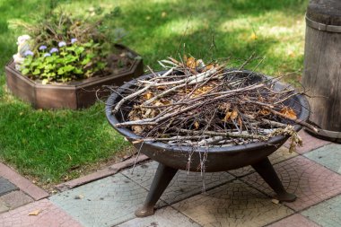 Taşınabilir demir şömine arka bahçe yaz yazlık kuru çırpı ile. Kamp ateşi hikayeler akşam için hazırlanan şenlik ateşi