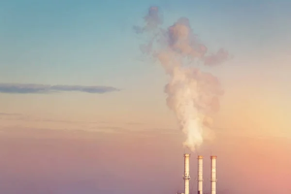 Trois pipes fumantes empilant des nuages de fumée blanche avec un fond spectaculaire de ciel couchant. Paysage industriel minimaliste. Processus d'échauffement climatique et effet de serre. Pollution de l'environnement — Photo