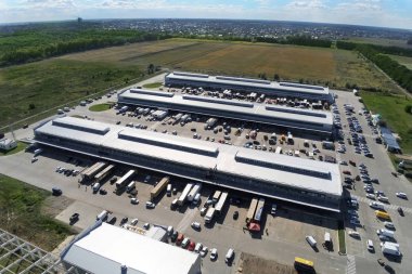 Şehir merkezindeki büyük modern sanayi deposu veya fabrika binalarının insansız hava aracı görüntüsü. Lojistik ulaşım kargo terminali.