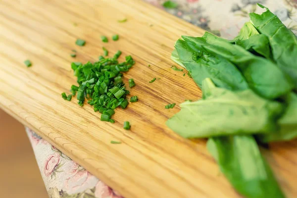 Espinacas verdes frescas picadas, cebolla cebolla cebolla en tabla de cortar de madera. Alimentación saludable de vitaminas — Foto de Stock