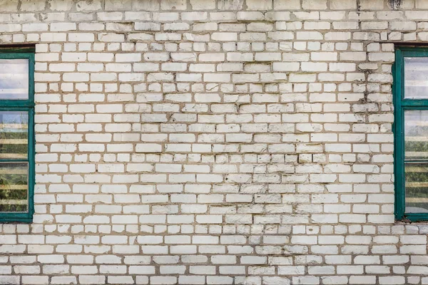 Stary brudny pęknięty biały ceglany mur z retro drewniane okna po stronie. Szare tło z teksturą — Zdjęcie stockowe