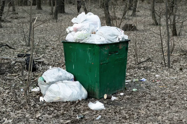 Alte rostige metallene grüne Mülltonnen voller Plastikmüll, die im Stadtpark oder Wald stehen. Umweltverschmutzung — Stockfoto