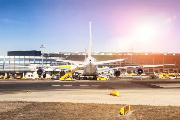 Stort bred-Body kommersiella passagerar flyg plan under underhåll och förberedelse av flygningen på internationell flyg plats. Service fordon och landnings brygga på flyg fältet — Stockfoto