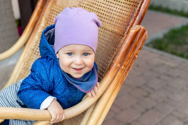 Retrato de lindo adorable niño caucásico divirtiéndose sentado en una mecedora de ratán de madera en la casa terraza patio trasero al aire libre —  Fotos de Stock