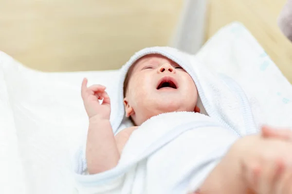 Cute infant baby in white towel crying after first bathing at bathroom. Newborn children healthcare and hygiene — Stock Photo, Image