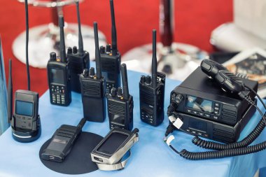 Birçok taşınabilir radyo alıcı-vericileri teknoloji fuarında masada. Farklı walkie-talkie radyo seti. Askeri ve sivil kullanım için iletişim cihazları seçimi