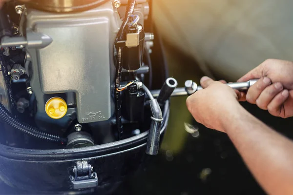 Mecánico reparación de motor inflable de la lancha en el garaje del barco. Servicio y mantenimiento estacional del motor del buque. Motor del buque con tapa abierta —  Fotos de Stock