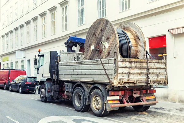 Camión entrega de suministro pesado carrete de cable eléctrico en la calle de la ciudad — Foto de Stock
