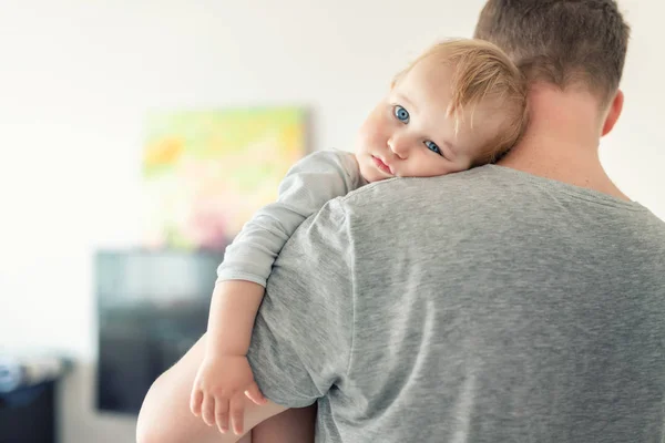 Primo piano ritratto di carino adorabile biondo caucasico bambino ragazzo sulla spalla padri al chiuso. Dolce bambino che si sente al sicuro sulla mano di papà. Responsabilità e assistenza all'infanzia. infanzia felice — Foto Stock