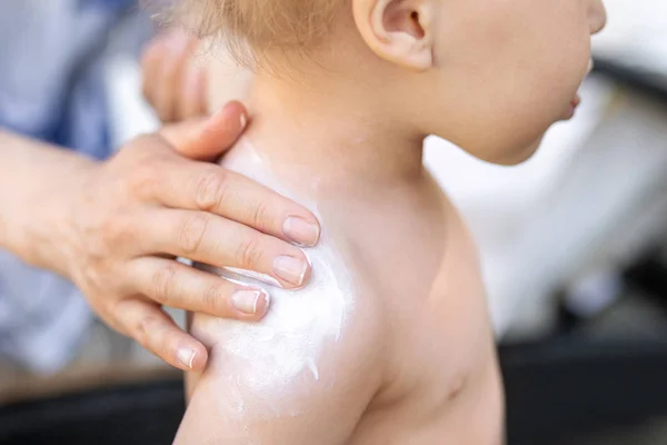 母亲应用防晒霜保护奶油可爱的幼儿男孩肩膀。妈妈在暑假期间用防晒化妆水保护宝宝免受阳光的伤害。旅行时间的儿童保健 — 图库照片