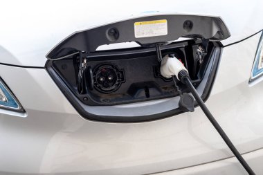 Yakın çekim modern elektrikli araba eski Avrupa şehrinin merkezinde şarj istasyonunda hızlı şarj ile pugged. Ecol dostu yeşil enerji araç. Sıfır emisyonlu taşıma