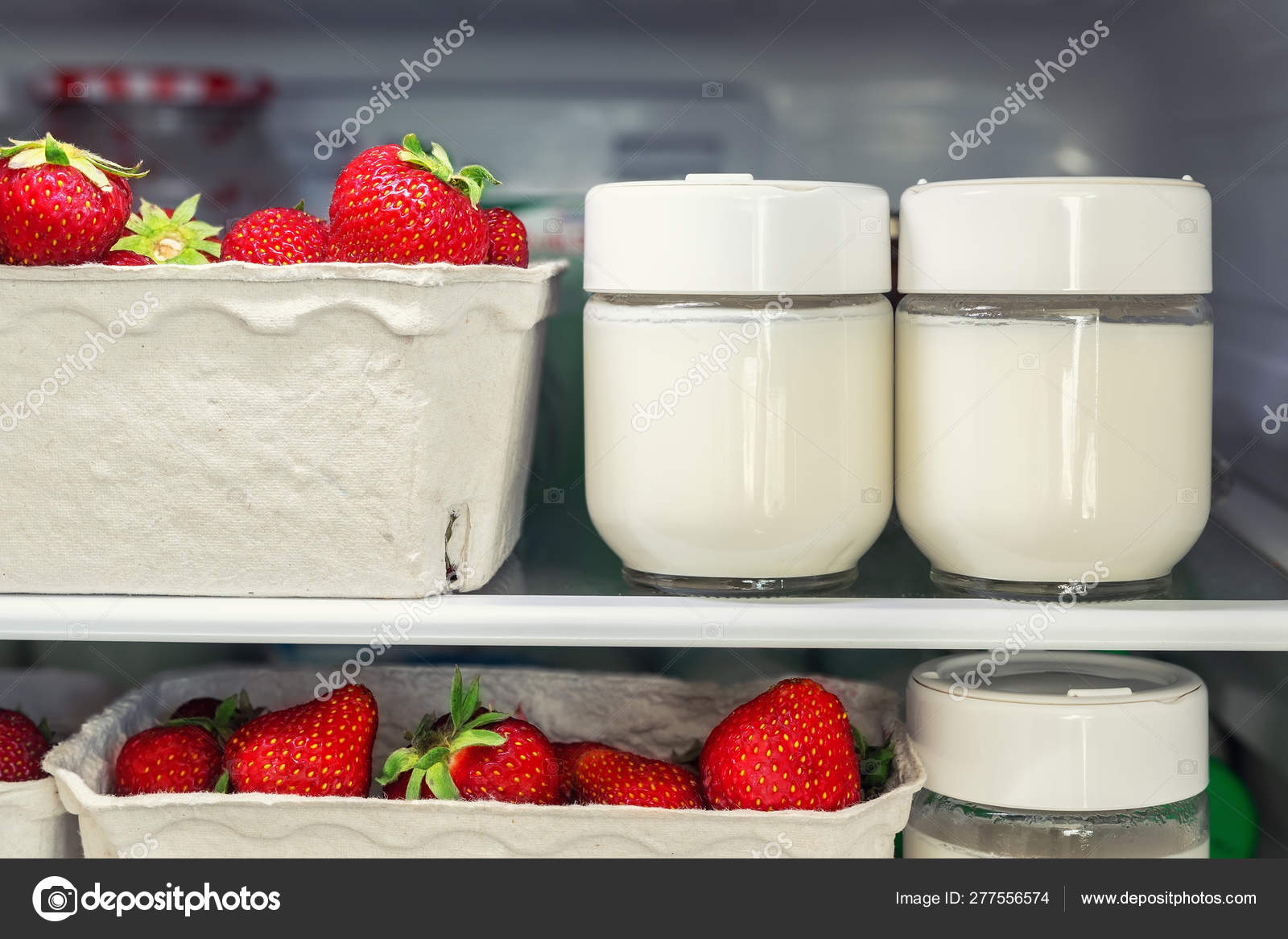 Refrigerator shelf with organic juicy strawberries in bio recycled paper  boxes and homemade natural milk yogurt. Fridge filled with berries in  cardboard containers. Healthy and eco friendly food diet Stock Photo by ©