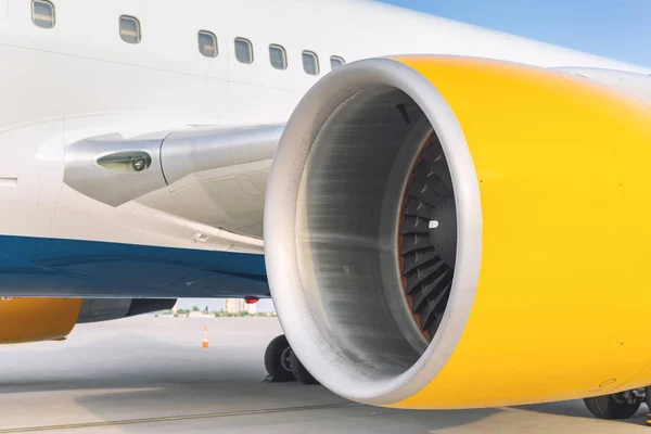 Крупный план большой коммерческий двигатель самолета, стоящий в воздухе после прибытия самолета в яркий солнечный день — стоковое фото