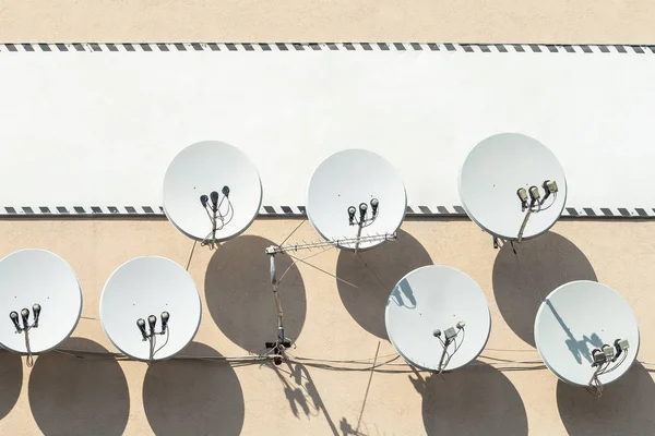 Muchos antena antena antena parabólica colgada en la pared del edificio con gran cartel blanco vacío en el fondo. Copyspace para el texto en cartel de la cartelera — Foto de Stock