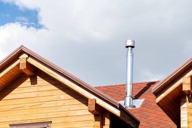 Modern ahşap kiriş yazlık villa evin çatısında Paslanmaz çelik baca borusu. Ev şömine ve ısıtma egzoz sistemi