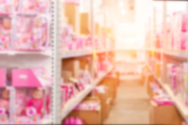 Abstract blurred background of wholesale girs toys and dolls shop. Shelves with pink gift boxes at storage of retail store