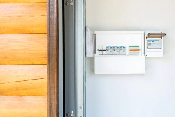 Eldistribution Board med uppsättning automatiska brytare och strömbrytare nära entrédörren till trä garagebyggnad. Hem elektrisk kontrollpanel — Stockfoto