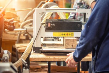 Modern profesyonel güç araçları bir sürü Marangozluk içinde craftman ahşap. Atölyede kalınlık makinesi ve dairesel testere ve diğer ekipman kullanan adam