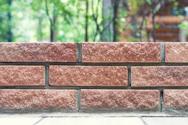 Arka planda bulanık park veya ev arka bahçesinde yeni taze tuğla duvar Düz çizgiler. Modern tuğla duvar açık. Yapı malzemeleri, aletler ve şantiye için ürün ekranı