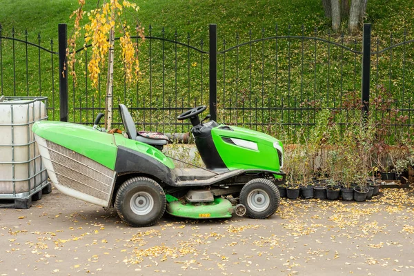 Büyük endüstriyel çim biçme makinesi şehir parkında park ayakta. Belediye sokak hizmet alanında yeşil çim biçme traktörü — Stok fotoğraf